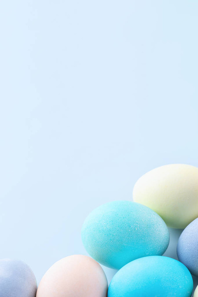 Colorful Easter eggs dyed by colored water isolated on a pale blue background, design concept of Easter holiday activity, close up, copy space. - Foto, Bild