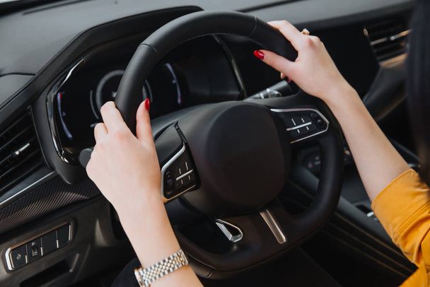 Womans hand on the steering wheel. - Фото, зображення