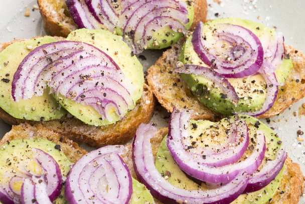 Sandwich con avocado fresco e cipolla su un piatto
 - Foto, immagini