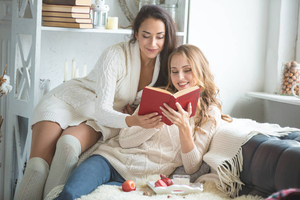 Girls on the couch with the book - Фото, изображение
