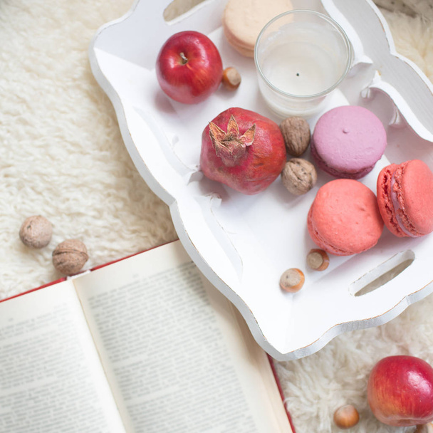 A book and a tray with fruits and macaroons - Foto, Imagen