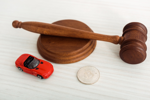 wooden gavel, model of car and metal coin on table  - Fotoğraf, Görsel