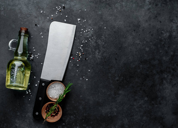 мясной топор, кухонный нож со специями на каменном фоне, с копировальным местом
 - Фото, изображение
