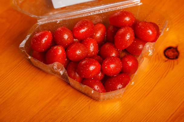 Pomodori ciliegia nel contenitore di plastica sul tavolo
 - Foto, immagini