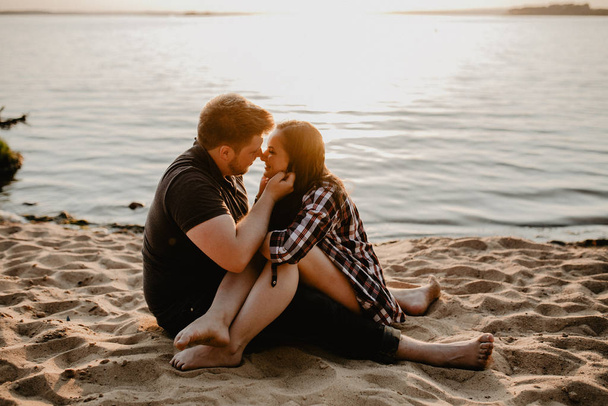 Lovely happy couple having fun near the lake. romantic photo at sunset time. Hugging  and smiling - Zdjęcie, obraz