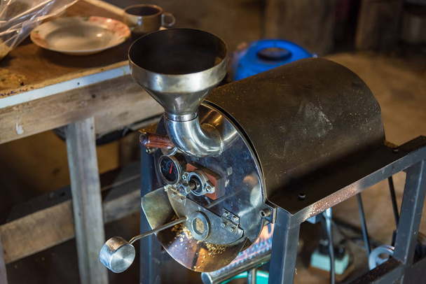 Grão de café torrado derramando da máquina torradeira para a bandeja de resfriamento
 - Foto, Imagem