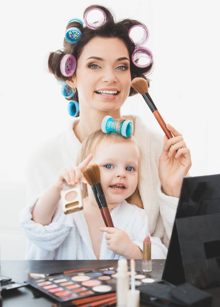 Beautiful woman and her daughter doing make up - 写真・画像