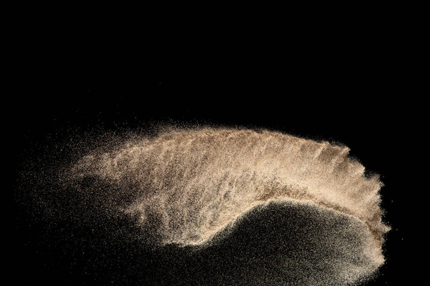 Brown colored sand splash.Dry river sand explosion isolated on black background. Abstract sand cloud. - Photo, Image