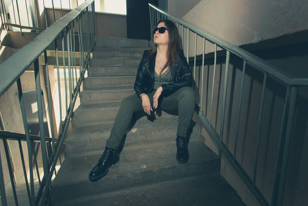 Női függetlenség és feminizmus koncepció - Lány a sötét lépcsőn katonai stílusban. - Fotó, kép