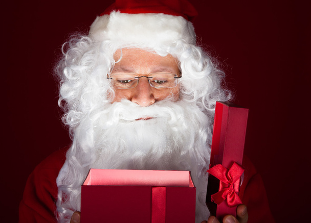 Close-up of santa looking in gift - Fotó, kép