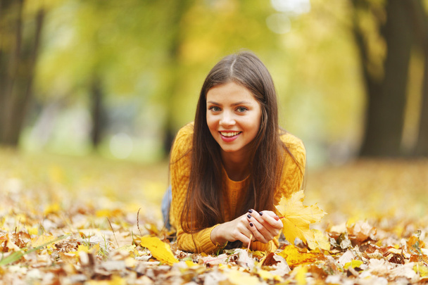 Girl laying on autumn leafs - Фото, зображення