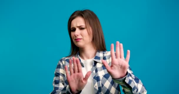 Unzufriedenes Mädchen im karierten Hemd schüttelt den Kopf und zeigt keine Geste isoliert auf blauem Hintergrund - Filmmaterial, Video
