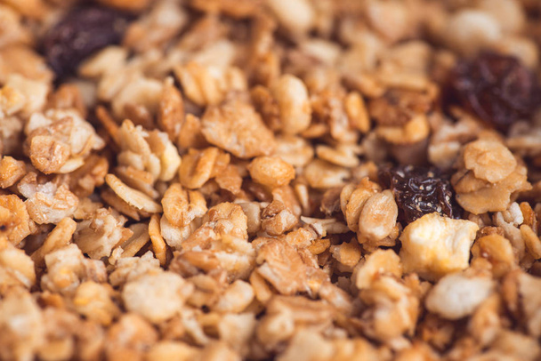 Useful and tasty muesli with nuts, rasins and flakes. Selective focus macro shot with very shallow depth of field. Healthy and vegetarian lifestyle - Photo, image