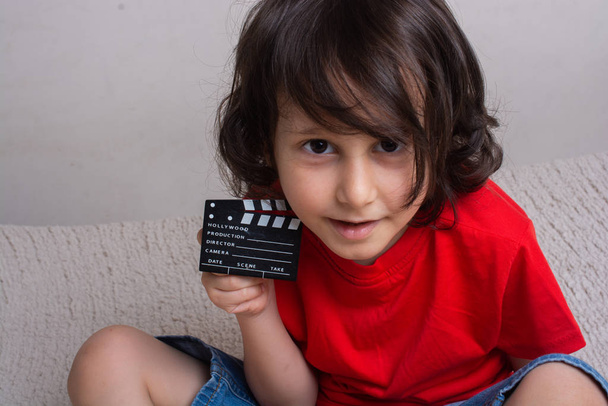 Küçük çocuğun elinde film yapım alkış tahtası - Fotoğraf, Görsel