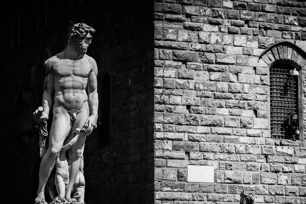 Grayscale shot of a male statue near a building - Foto, Imagen