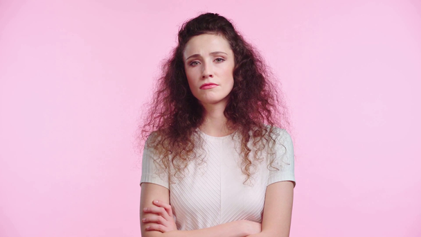 smutna kobieta z skrzyżowanymi ramionami odizolowana na różowo  - Materiał filmowy, wideo