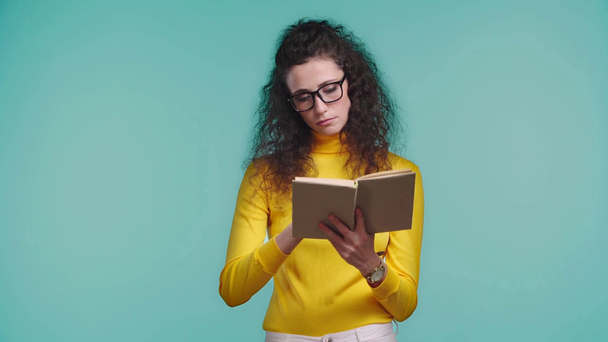 sad woman reading book isolated on turquoise  - Footage, Video
