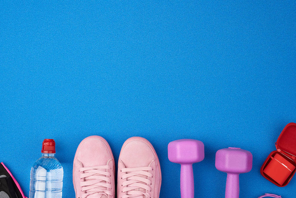 plastové fialové činky, sportovní oblečení, voda, růžové tenisky  - Fotografie, Obrázek