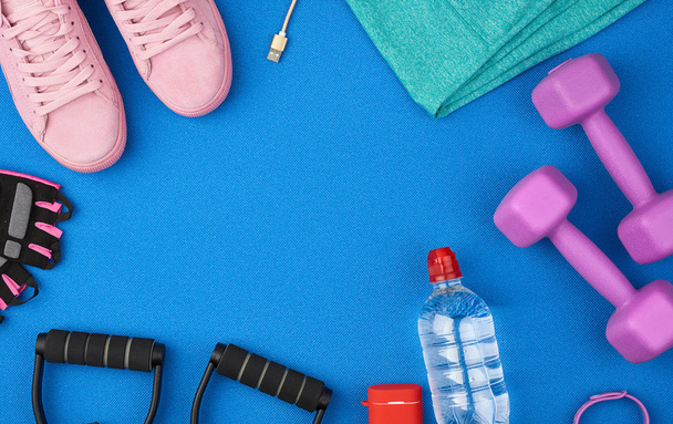 plastic purple dumbbells, sportswear, water, pink sneakers and w - Photo, Image
