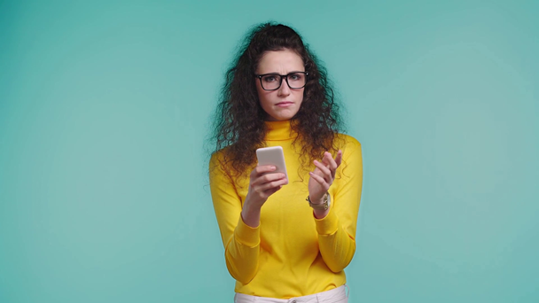 järkyttynyt nainen käyttää älypuhelinta eristetty turkoosi
  - Materiaali, video
