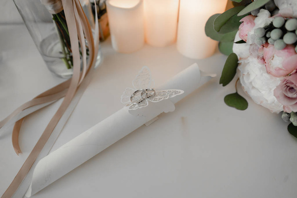 Luxury silver jewelry ring in box close up. Rings on the table near candles. Preparation for wedding concept - Photo, Image