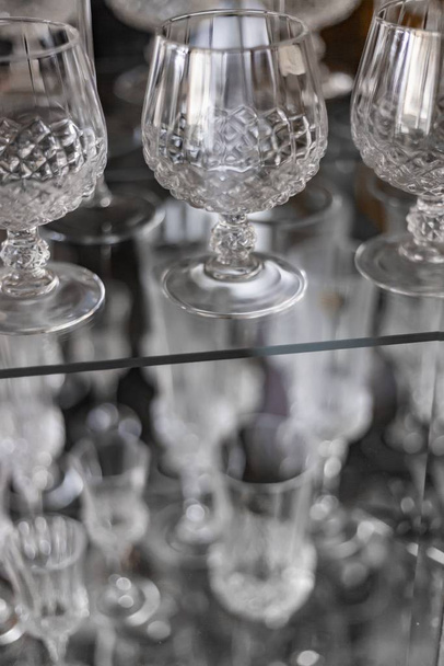 Vertical closeup shot of crystal cognac glasses in a closet - Foto, Imagem