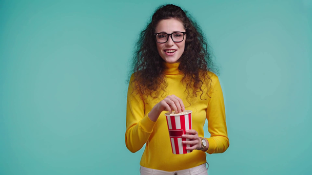 smiling woman watching movie isolated on turquoise  - Footage, Video