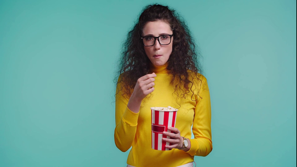шокированная женщина ест попкорн, изолированный от бирюзы
  - Кадры, видео