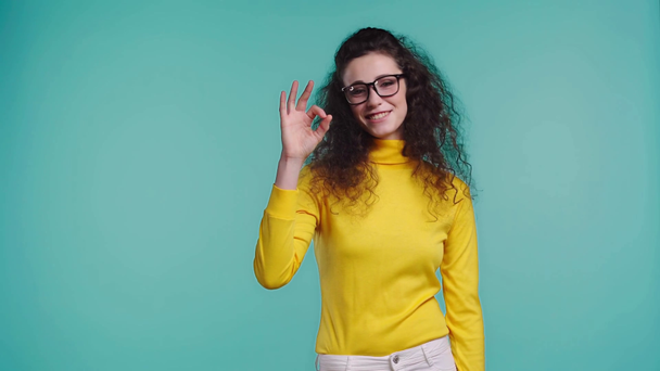 smiling woman showing ok isolated on turquoise  - Кадри, відео