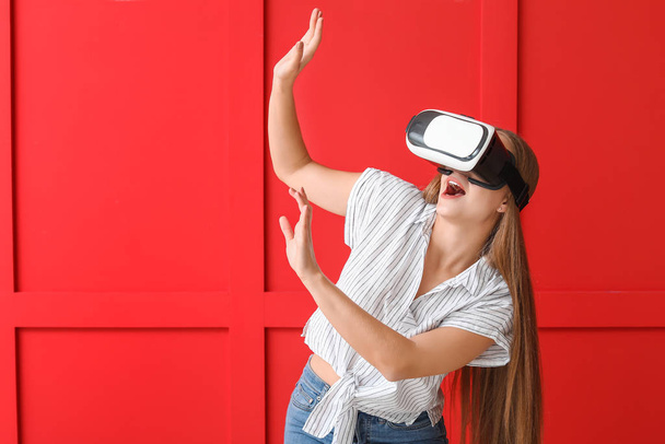 Young woman with VR glasses against color wall - Photo, Image
