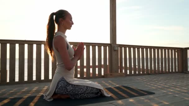 Biała dziewczyna medytacja na dachu w słońcu - Materiał filmowy, wideo