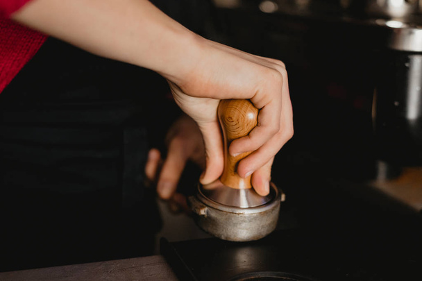 Barista tamping coffee with a tamper - Foto, Bild