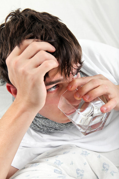 Teenager with Flu drinks Water - 写真・画像