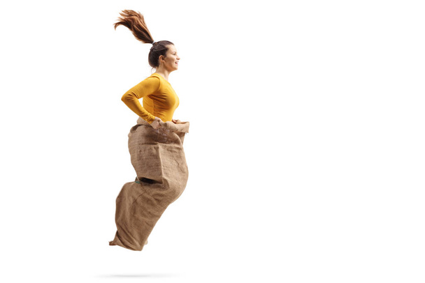 Young female jumping in a sack  - Φωτογραφία, εικόνα
