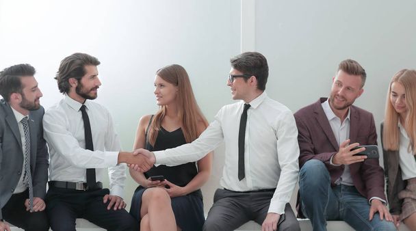 young business people shaking hands while sitting in the office lobby - Fotoğraf, Görsel