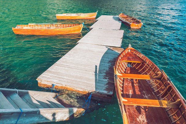 порожні дерев'яні човни біля причалу на гірському озері
 - Фото, зображення