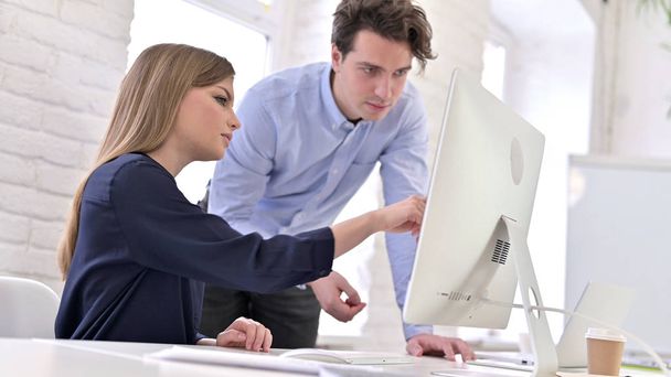 Young Man and Woman Discussing Work on Desktop - Φωτογραφία, εικόνα