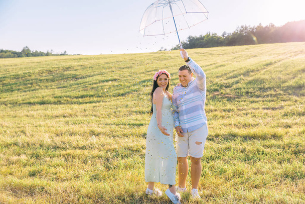 casal em roupas elegantes no campo com guarda-chuva transparente. Um... - Foto, Imagem