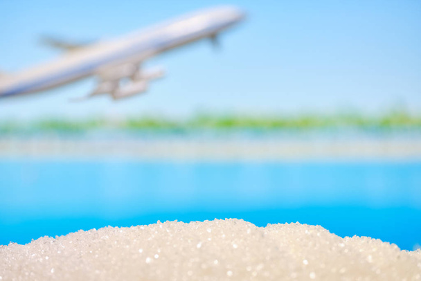 Abstract beach - sand and sea as a background with a flying plane. Vacation and travel concept. - Fotoğraf, Görsel
