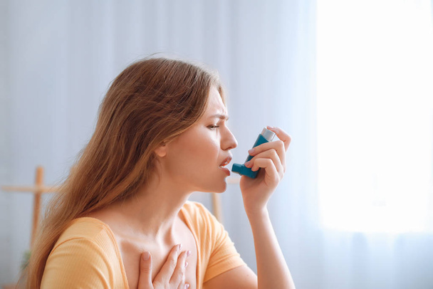 Νεαρή γυναίκα με αναπνευστήρα που παθαίνει κρίση άσθματος στο σπίτι - Φωτογραφία, εικόνα