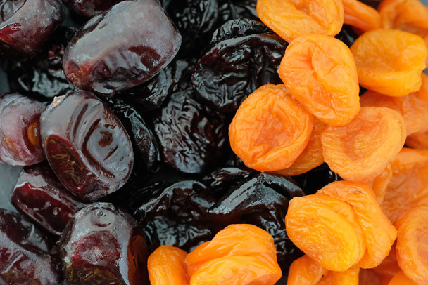 Dried apricots, prunes and dates top view. Delicious turkish dried fruits background. Mountain dried apricots of small size. - 写真・画像