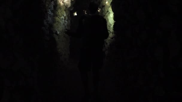 ein Mann bahnt sich seinen Weg durch die Höhle - Filmmaterial, Video