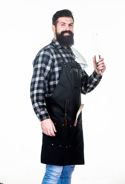 Barbecue and grill. Barbecue cook using kitchen tongs. Bearded man holding barbecue tongs in hands. Chef hipster holding stainless steel tongs. Using tongs for preparing and serving barbecue food - Foto, immagini