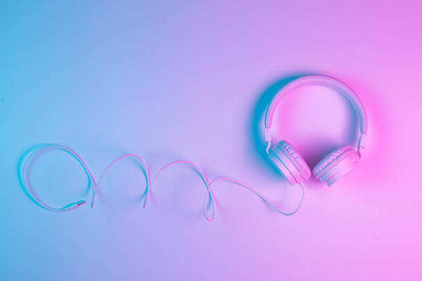 Retro 90s style photo of white stylish wireless headphone in neon lights. Music concept. - Photo, Image