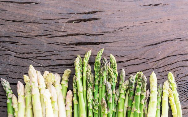Green and white types of asparagus sprouts on wooden table.  Top - Fotografie, Obrázek
