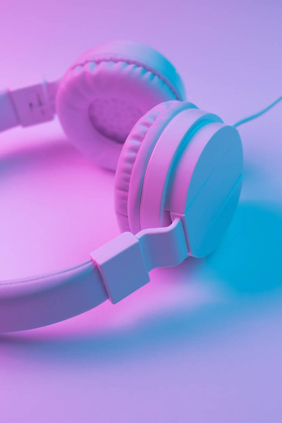 Retro 90s style photo of white stylish wireless headphone in neon lights. Music concept. - Fotoğraf, Görsel