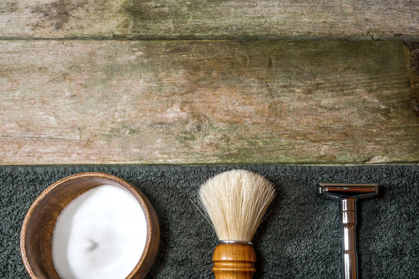 Retro safety razor, shaving brush and lather in bowl. Old-school wet shaving in rustic wooden table, with copy space. - Photo, Image