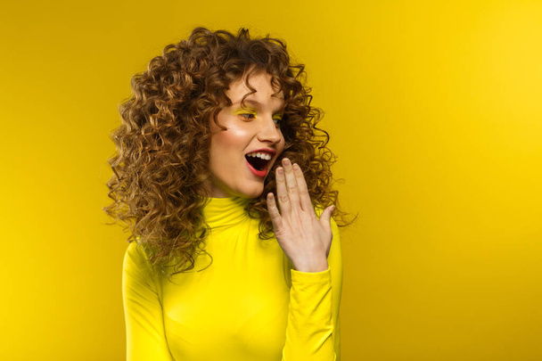 Wow. Reaction on unexpected news. Beautiful women with wide open eyes covering open mouth with hand, being surprised and shocked. Copy space,yellow background. Expressive faces. Body language concept - Фото, изображение