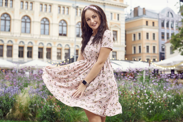 Fiatal gyönyörű fényes lány egy nyári ruha nevet a városi parkban - Fotó, kép