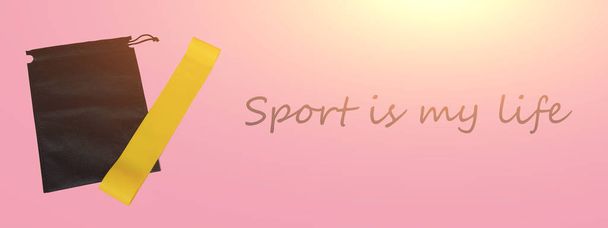 スポーツイエロー弾性バンド。スポーツ用品、自宅でのスポーツ、スポーツに関する記事、ホームスポーツのための機器。ピンクの背景に黄色のゴムバンド。スポーツは私の人生 - 写真・画像